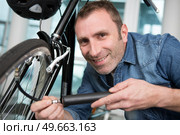 man inflating bicycle tyre. Стоковое фото, агентство Ingram Publishing / Фотобанк Лори