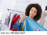 attractive seamstress measuring a length of fabric. Стоковое фото, агентство Ingram Publishing / Фотобанк Лори