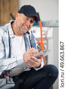 mature serviceman writing on clipboard. Стоковое фото, агентство Ingram Publishing / Фотобанк Лори