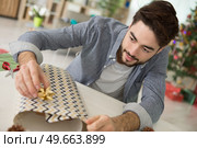 man wrapping christmas presents. Стоковое фото, агентство Ingram Publishing / Фотобанк Лори