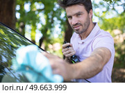 cheerful man cleaning car windscreen. Стоковое фото, агентство Ingram Publishing / Фотобанк Лори