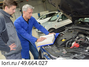 student with instructor repairing a car during apprenticeship. Стоковое фото, агентство Ingram Publishing / Фотобанк Лори