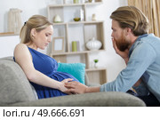 expectant couple are worried as woman experiences pains. Стоковое фото, агентство Ingram Publishing / Фотобанк Лори
