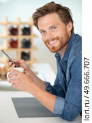 young man texting while drinking coffee. Стоковое фото, агентство Ingram Publishing / Фотобанк Лори