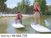 silhouette of perfect couple engage standup paddle boarding. Стоковое фото, агентство Ingram Publishing / Фотобанк Лори