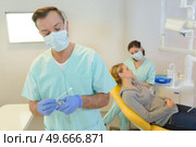 dentist curing a woman patient in the dental office. Стоковое фото, агентство Ingram Publishing / Фотобанк Лори