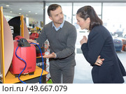 Woman looking at machine on display. Стоковое фото, агентство Ingram Publishing / Фотобанк Лори