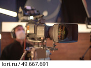 masked cameraman is filming a television show in the studio. TV. Стоковое фото, агентство Ingram Publishing / Фотобанк Лори