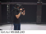 cameraman on the set of the ultimate fighting show. Masked against coronavirus. Стоковое фото, агентство Ingram Publishing / Фотобанк Лори