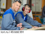 two men working with a machine. Стоковое фото, агентство Ingram Publishing / Фотобанк Лори