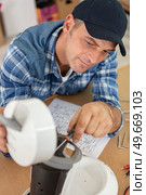 man in workshop repairing broken coffee machine. Стоковое фото, агентство Ingram Publishing / Фотобанк Лори