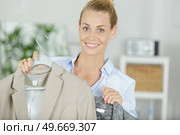 attractive stylish smiling woman choosing a jackeyt. Стоковое фото, агентство Ingram Publishing / Фотобанк Лори