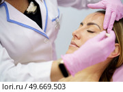 Aesthetic doctor painting on the face of his middle-aged patient the areas to be treated with botulinum toxin.. Aesthetic doctor painting on the face of his patient the areas to be treated with botulinum toxin. Стоковое фото, агентство Ingram Publishing / Фотобанк Лори