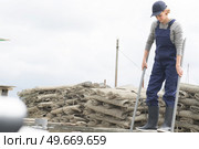 female worker with oysters in metal bag on farm. Стоковое фото, агентство Ingram Publishing / Фотобанк Лори
