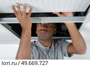 man installs suspended ceiling in house. Стоковое фото, агентство Ingram Publishing / Фотобанк Лори