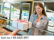 Lady accepting gift wrapped box in a bakery. Стоковое фото, агентство Ingram Publishing / Фотобанк Лори