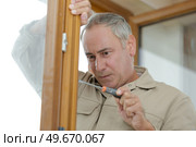 mature window fitter using screwdriver. Стоковое фото, агентство Ingram Publishing / Фотобанк Лори