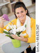 woman tending an orchid at home. Стоковое фото, агентство Ingram Publishing / Фотобанк Лори