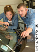 vehicle technician checking wipers with the apprentice. Стоковое фото, агентство Ingram Publishing / Фотобанк Лори