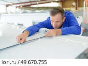 man is working on the roof of a campervan. Стоковое фото, агентство Ingram Publishing / Фотобанк Лори