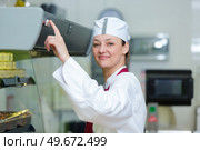 female worker with hand on chiller unit power button. Стоковое фото, агентство Ingram Publishing / Фотобанк Лори