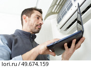 air conditioning technician preparing to install new air conditioner. Стоковое фото, агентство Ingram Publishing / Фотобанк Лори