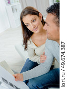 happy couple doing their accounts sat in a couch. Стоковое фото, агентство Ingram Publishing / Фотобанк Лори