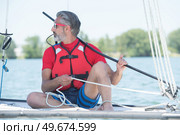 handsome mature man sailing on hobby catamaran. Стоковое фото, агентство Ingram Publishing / Фотобанк Лори