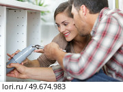 a couple fixing kitchen sink. Стоковое фото, агентство Ingram Publishing / Фотобанк Лори