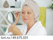 woman plucking eyebrows by the window. Стоковое фото, агентство Ingram Publishing / Фотобанк Лори