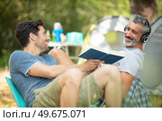 friends relaxing outside tents on camping holiday. Стоковое фото, агентство Ingram Publishing / Фотобанк Лори