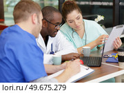 team of doctors working on laptop in medical office. Стоковое фото, агентство Ingram Publishing / Фотобанк Лори