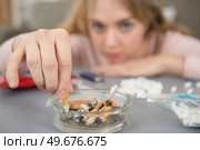 young lady stubbing a cigarette into an ashtray. Стоковое фото, агентство Ingram Publishing / Фотобанк Лори