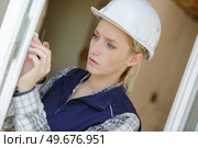 woman worker screwing a window. Стоковое фото, агентство Ingram Publishing / Фотобанк Лори