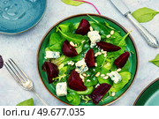 Tasty salad with beets, blue cheese, herbs and pine nuts on gray background. Fresh salad with beets, cheese and greens. Стоковое фото, агентство Ingram Publishing / Фотобанк Лори