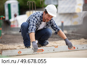 construction worker screeding on outdoor site. Стоковое фото, агентство Ingram Publishing / Фотобанк Лори