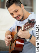 a handsome musician playing guitar. Стоковое фото, агентство Ingram Publishing / Фотобанк Лори