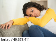 sad woman locating on comfortable couch. Стоковое фото, агентство Ingram Publishing / Фотобанк Лори