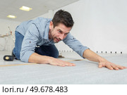 a worker cutting linoleum tape-measure. Стоковое фото, агентство Ingram Publishing / Фотобанк Лори