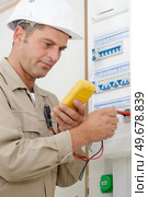 adult electrician builder working with fuseboard. Стоковое фото, агентство Ingram Publishing / Фотобанк Лори