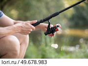 man holds fly rod with one hand. Стоковое фото, агентство Ingram Publishing / Фотобанк Лори