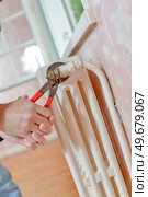 male worker is repairing the radiator. Стоковое фото, агентство Ingram Publishing / Фотобанк Лори