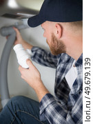plumber fixes sink siphon by two pipe-wrenches in bathroom. Стоковое фото, агентство Ingram Publishing / Фотобанк Лори