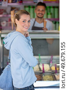 confectioner selling ice cream to young woman. Стоковое фото, агентство Ingram Publishing / Фотобанк Лори