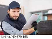 professional car mechanic balancing car wheel. Стоковое фото, агентство Ingram Publishing / Фотобанк Лори