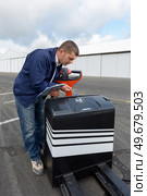 worker inspecting serial number of heavy loader cart. Стоковое фото, агентство Ingram Publishing / Фотобанк Лори