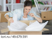 woman unpacking boxes sitting on the floor. Стоковое фото, агентство Ingram Publishing / Фотобанк Лори