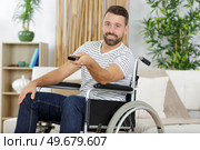 handicapped man using a tv remote control. Стоковое фото, агентство Ingram Publishing / Фотобанк Лори