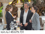 young waitress is serving a beautiful couple in a restaurant. Стоковое фото, агентство Ingram Publishing / Фотобанк Лори