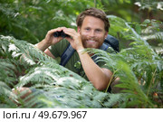 man looks through binoculars in nature. Стоковое фото, агентство Ingram Publishing / Фотобанк Лори